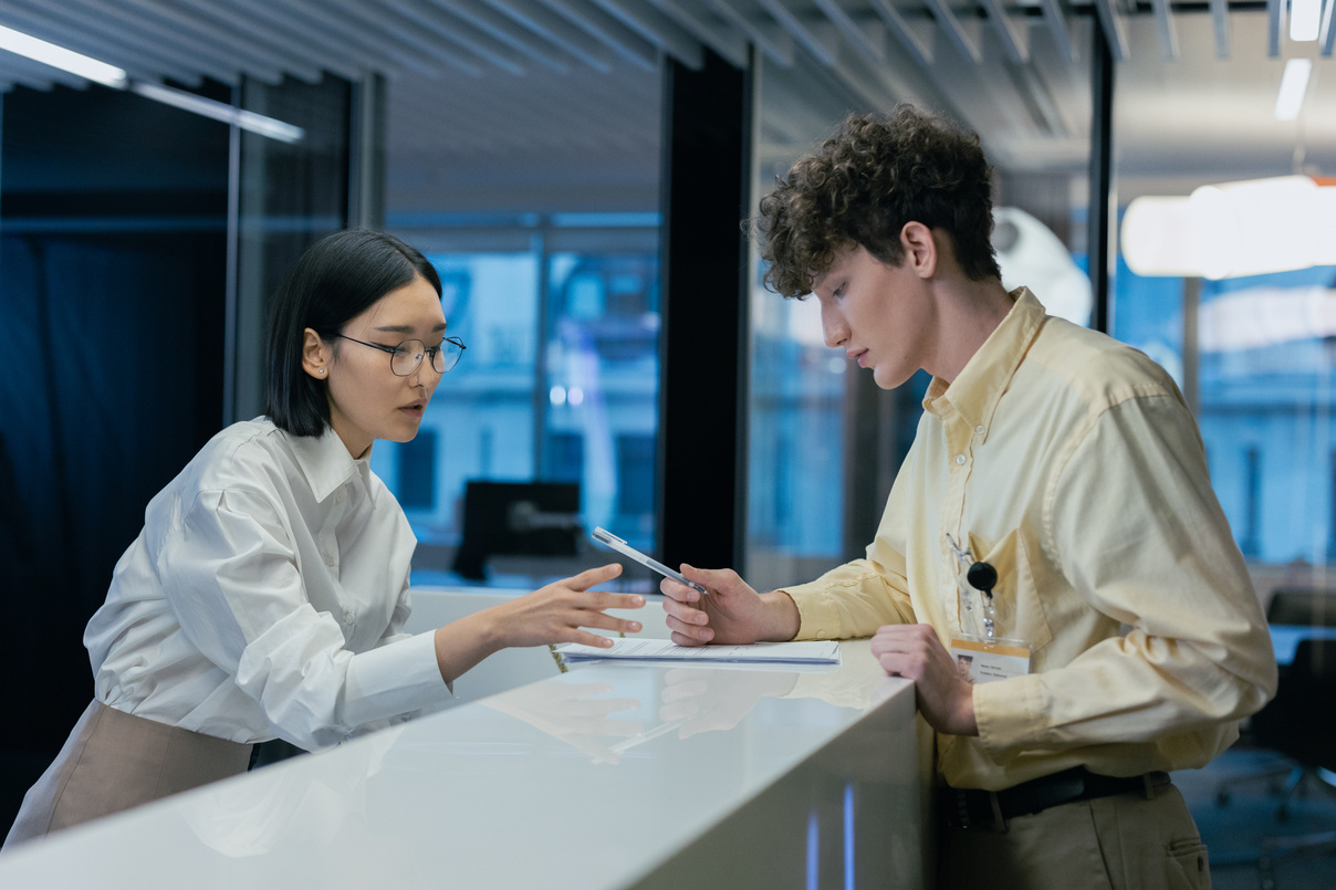 Recpetionist helping Man Fill Out Papers